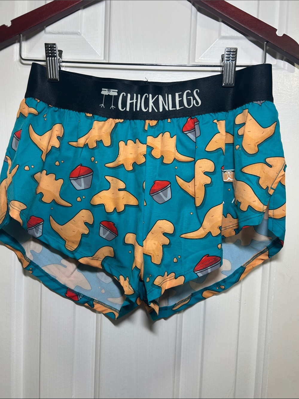 Chicknlegs, Women’s Teal Dino Snack Print Athletic Shorts, Size Small